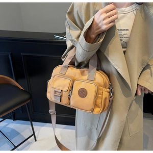Detail of water-resistant nylon handbag with functional multi-pocket utility design