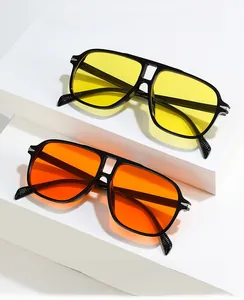 Close-up of dual-beam aviator sunglasses with yellow and orange lenses on white steps