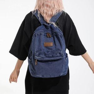 Blue denim backpack featuring vintage wash with brown leather patch and large capacity design