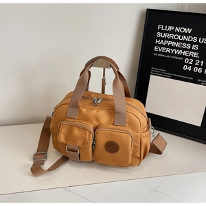 Close-up of waterproof ginger yellow nylon handbag with functional multi-zipper pockets