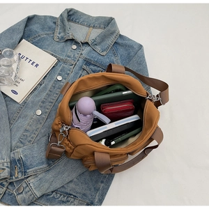 Spacious interior of brown water-resistant nylon crossbody bag with daily essentials