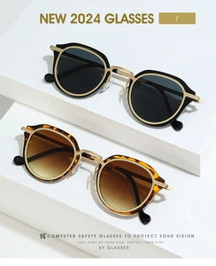Detailed view of oval sunglasses with gold metal bridge and tortoiseshell texture