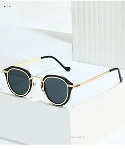 Detail of oval sunglasses featuring black acetate frames with gold metal accents