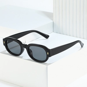 Classic black rectangular sunglasses with dark lenses on a geometric display