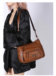Sac à bandoulière en cuir souple marron avec poches zippées et boucle métallique en cœur