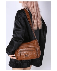 Vue latérale du sac à bandoulière en cuir PU marron avec sangle réglable et boucle en cœur