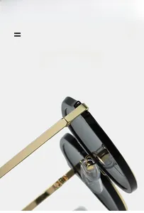 Detail of oval sunglasses featuring black frames and flexible golden metal hinges