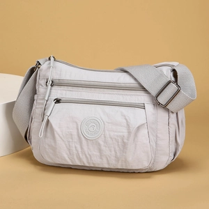 Light gray waterproof nylon crossbody bag with multiple pockets and adjustable strap
