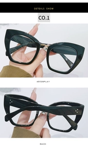Detail view of bold black cat-eye glasses frame featuring gold metal bridge and triple rivets