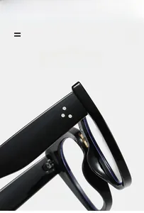 Detail of black cat-eye eyeglass frames showing silver rivets and high-gloss texture