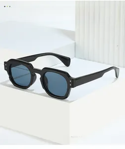 Detail of square black frame sunglasses with blue lenses and silver rivet accents