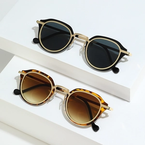 Retro oval sunglasses in black and tortoiseshell with gold metal frames on white display