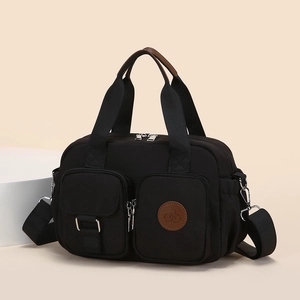 Waterproof black nylon crossbody tote bag with dual zipper pockets and top handles