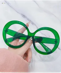 Detailed close-up of oversized translucent green round frame glasses with polished finish