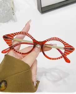 Detail of red cat-eye glasses frame with white stripes and silver hinge accents