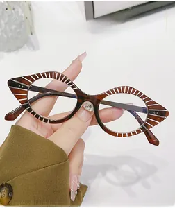 Close-up of amber cat-eye glasses frame with white radial stripes and polished finish