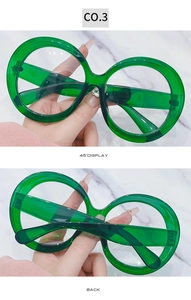 Detail view of oversized round sunglasses in emerald green resin with a 45-degree angle