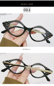 Detail view of cat eye glasses with black and white stripes and gold metal temples