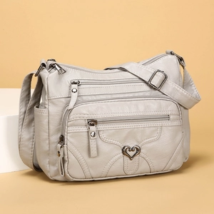 Sac bandoulière en cuir souple beige avec poches zippées et boucle en forme de coeur