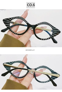 Detail view of cat eye glasses frames with black and white striped patterns and gold temples