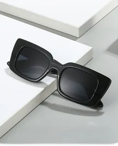 Détail de lunettes de soleil carrées noires mates sur un support géométrique