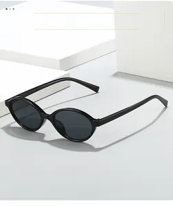 Close-up of retro black oval frame sunglasses with dark grey lenses on white cubes