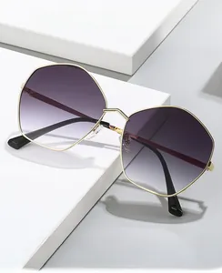 Detail of irregular gold metal polygon frame sunglasses with purple gradient lenses