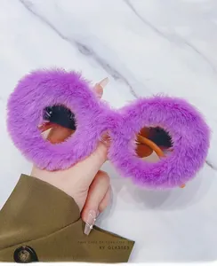 Detail of round sunglasses with purple plush fuzzy frames and orange temples