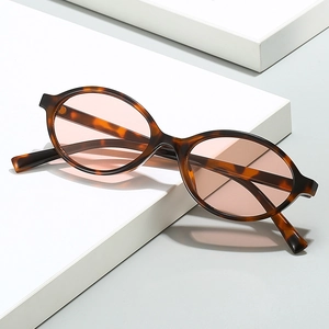 Retro tortoiseshell oval sunglasses with light pink lenses on white geometric block