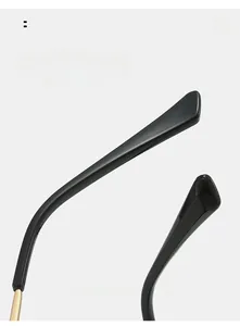 Detailed close-up of ergonomic curved gold metal hinges and black temple tips of sunglasses