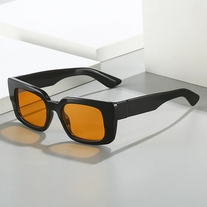 Lunettes de soleil carrées noires avec verres ambrés sur des cubes géométriques