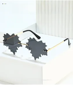 Detail of leaf-shaped rimless sunglasses with gold metal frame and grey lenses