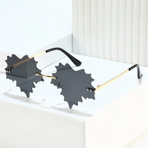 Frameless maple leaf sunglasses with gold metal frame and dark grey lenses on white display