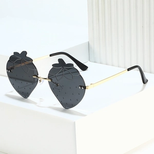 Rahmenlose Erdbeere Sonnenbrille mit grauen Gläsern und goldenen Metallbügeln auf weißem Sockel