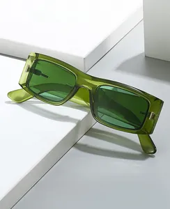 Détail de lunettes de soleil carrées vert translucide avec charnières en métal doré