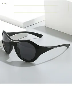 Vue détaillée de lunettes de soleil Y2K noires sur un présentoir blanc minimaliste