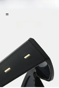 Détails de lunettes de soleil carrées noires avec accents métalliques dorés sur les branches