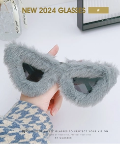 Detail of creative cat-eye sunglasses with plush grey faux fur trim and dark lenses