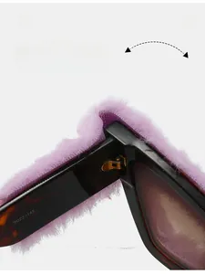 Detail of creative cat-eye sunglasses featuring purple faux fur trim and gold hinges