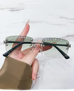 Detail of rimless sunglasses featuring crystal rhinestones and green gradient lenses