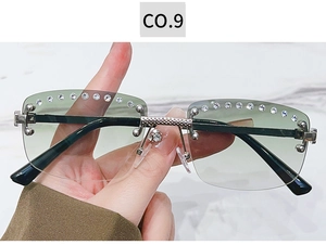Close-up of rimless sunglasses with green gradient lenses and sparkling rhinestone trim