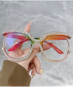 Dettaglio di occhiali quadrati oversize con montatura sfumata arcobaleno e strass brillanti