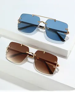 Close-up of rimless square sunglasses with blue and brown gradient lenses and gold bridge