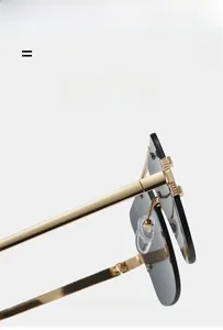 Close-up of golden metal sunglasses temple with crystal inlay and dark lenses