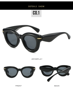 Close-up of black chunky oval sunglasses with golden olive metal hinges on side