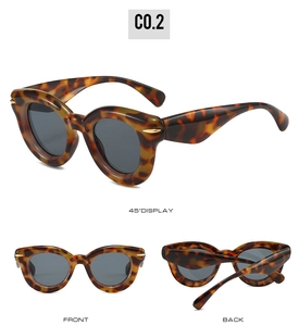 Detail view of tortoiseshell cat eye sunglasses with gold accents and grey lenses