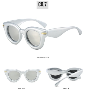 Detail of silver puffy oval sunglasses featuring golden rivets and multi-angle views