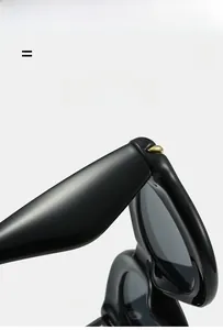 Detail of durable metal hinges and textured curved temples on black oval sunglasses