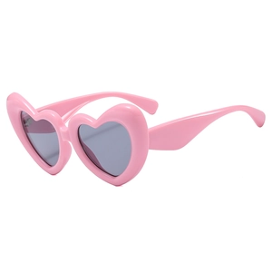 Lunettes de soleil coeur rose avec verres gris foncé sur un fond blanc pur