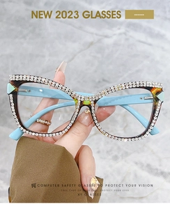 Close-up of luxury cat-eye glasses featuring handmade diamond chain and blue temples